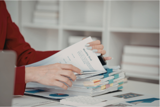 Compliance manager reviewing adviser files and FCA compliance reports in a financial advice office.
