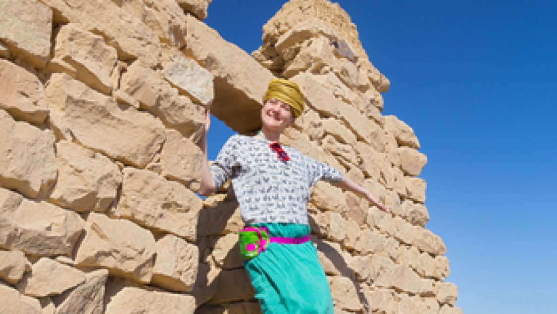 Tourist,With,Turban,Posing,In,Front,Of,Ruined,Stone,House